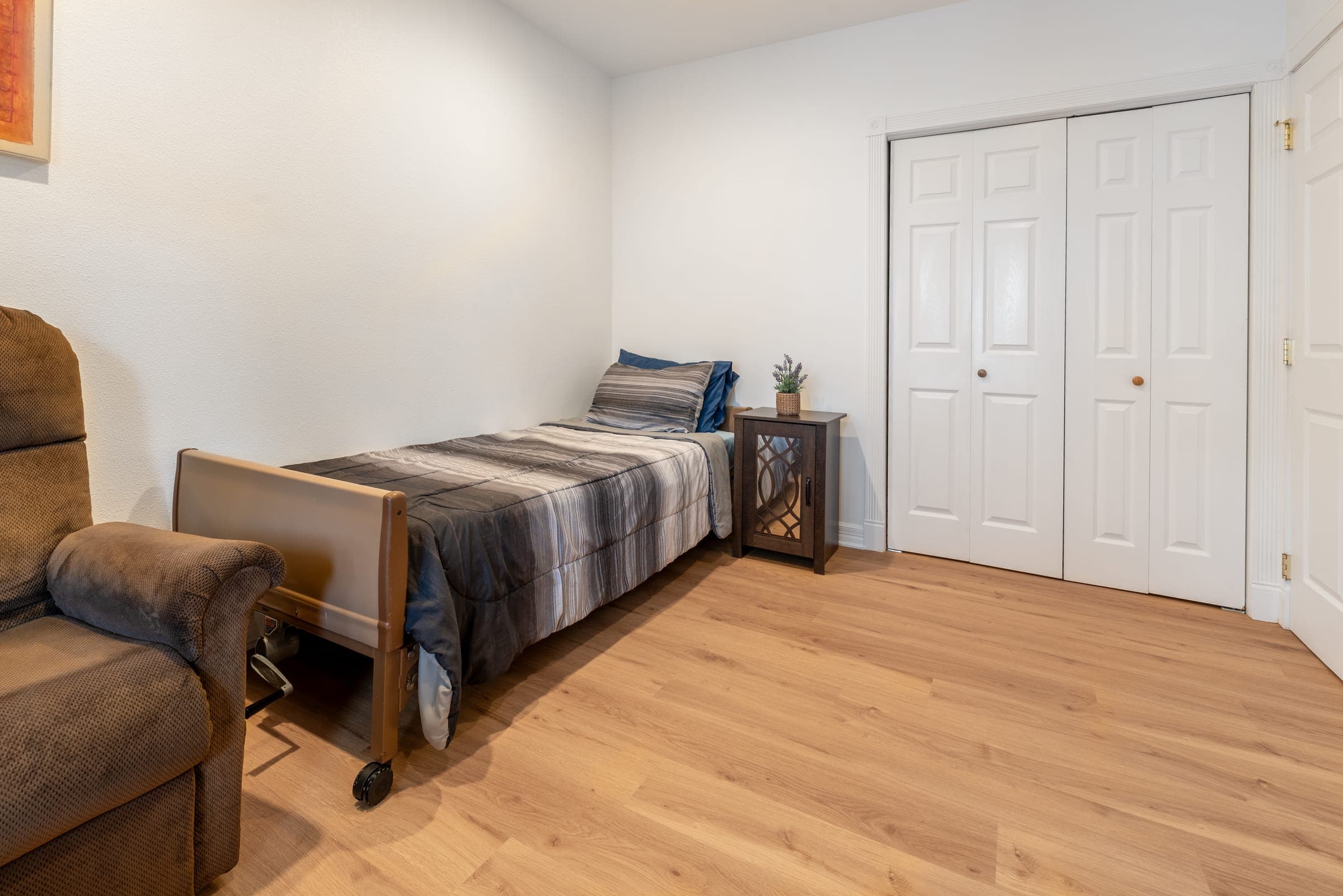 Bedroom with an adjustable care bed, a nightstand, and a double closet