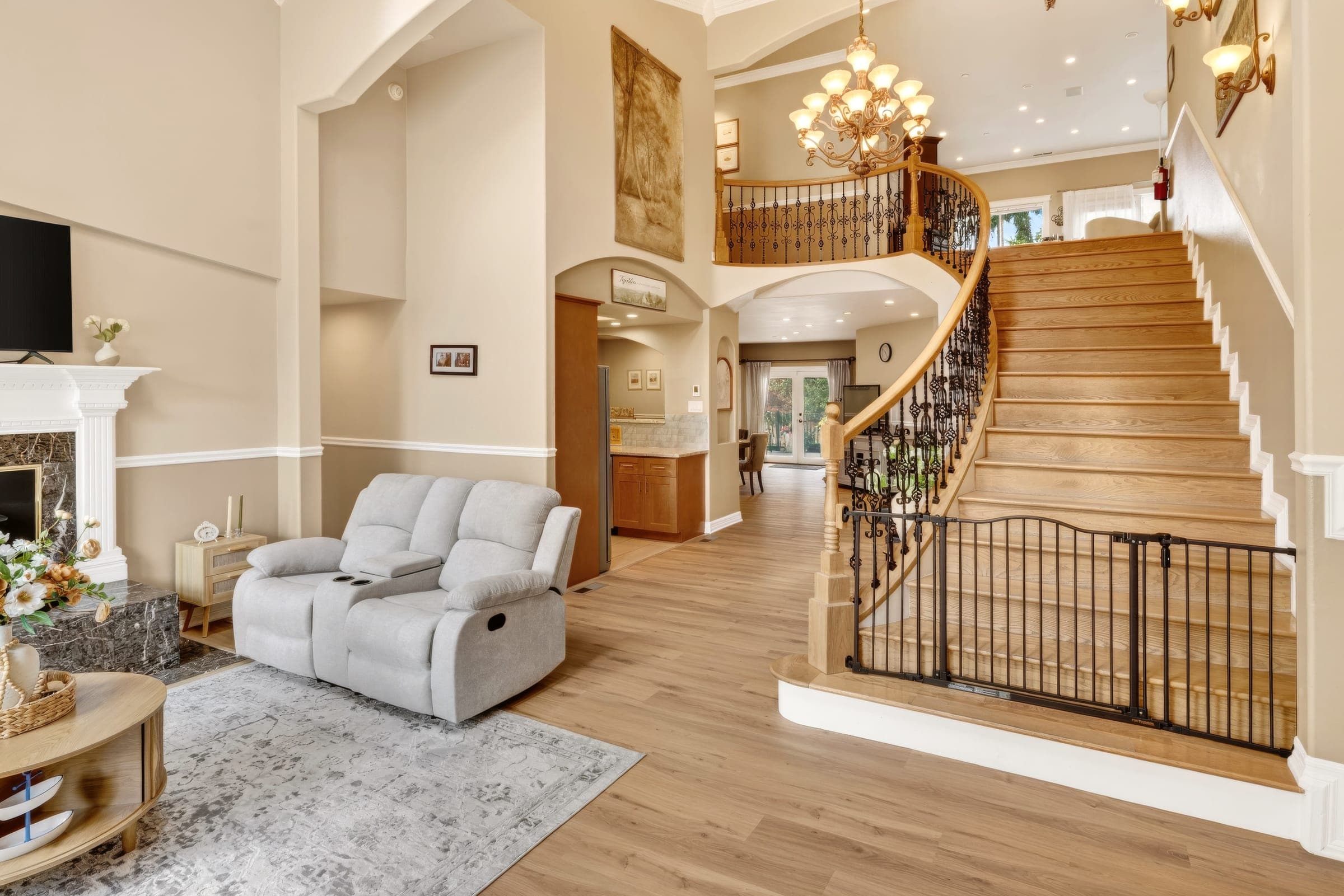 Open hall with a curved staircase and a chandelier